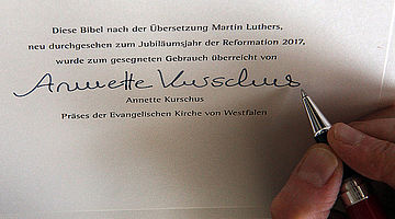 Tausend Bibeln mit eigenhändiger Widmung von Präses Annette Kurschus.