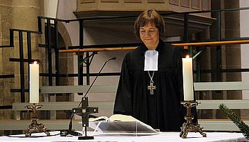 Präses Annette Kurschus mit der neuen Bibel am Altar des Herforder Münsters. Foto: EKvW