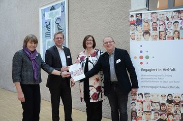 Das Projekt „Engagiert in Vielfalt – Wahrnehmung und Stärkung ehrenamtlicher Arbeit mit Geflüchteten in Stadt und Land“ ist abgeschlossen. Agnes Heuvelmann vom Ministerium für Kinder, Familie, Flüchtlinge und Integration (MKFFI), Landeskirchenr Das Projekt „Engagiert in Vielfalt – Wahrnehmung und Stärkung ehrenamtlicher Arbeit mit Geflüchteten in Stadt und Land“ ist abgeschlossen. Agnes Heuvelmann vom Ministerium für Kinder, Familie, Flüchtlinge und Integration (MKFFI), Landeskirchenrat Dr. Jan-Dirk Döhling, Jadranka Thiel, ebenfalls MKFFI, und Projektleiter Helge Hohmann vom Institut für Kirche und Gesellschaft präsentieren den Abschlussbericht. Foto: IKG