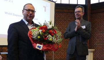 Blumen für Holger Erdmann. Es applaudiert Pfarrer Thomas Groll. Foto: Kirchenkreis Münster