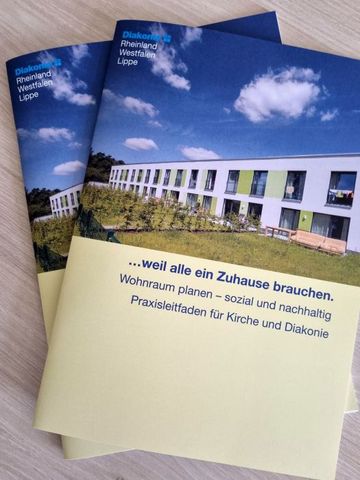 Zwei Broschüren liegen auf einem Tisch