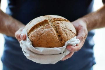 zwei Hände halten einen runden Brotlaib