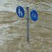 Überflutete Straße: Straßenschild ragt aus dem Wasser