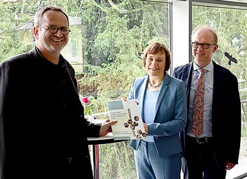 Fred Sobiech (li. ) und Thomas Böhme überreichen Präses Annette Kurschus den neuen Lehrplan. Foto: PI Fred Sobiech (li. ) und Thomas Böhme überreichen Präses Annette Kurschus den neuen Lehrplan. Foto: PI