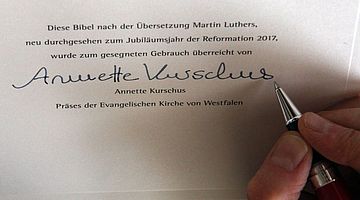 Präses Kurschus beim Unterschreiben der Lutherbibel. Bild: EKvW