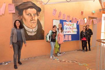 Lehrerin und Projektkoordinatorin Tina Jelveh mit einigen Schülerinnen vor den 103 »ausgezeichneten« Thesen. Foto: Tina Jelveh/EGG